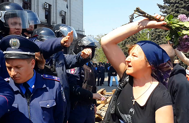 Γυναίκα στην Οδησσό “χτυπά” τους αστυνομικούς με λουλούδια: “Έπρεπε να ντρέπεστε” (vid)